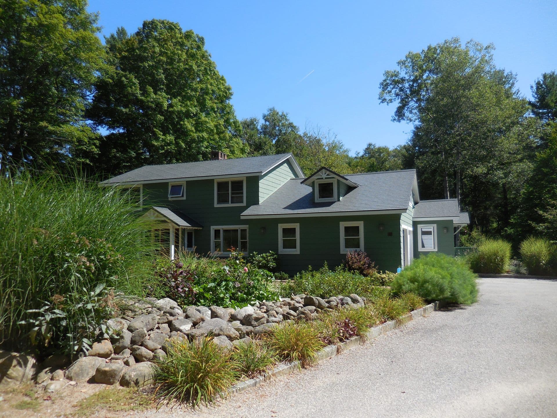blue home with stones and grass